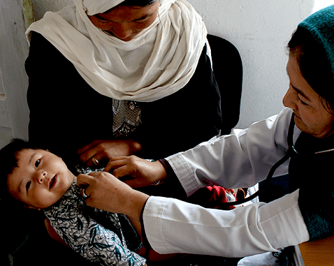 A midwife performs a check-up on a baby.