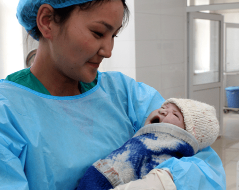 A midwife holds a newborn baby.