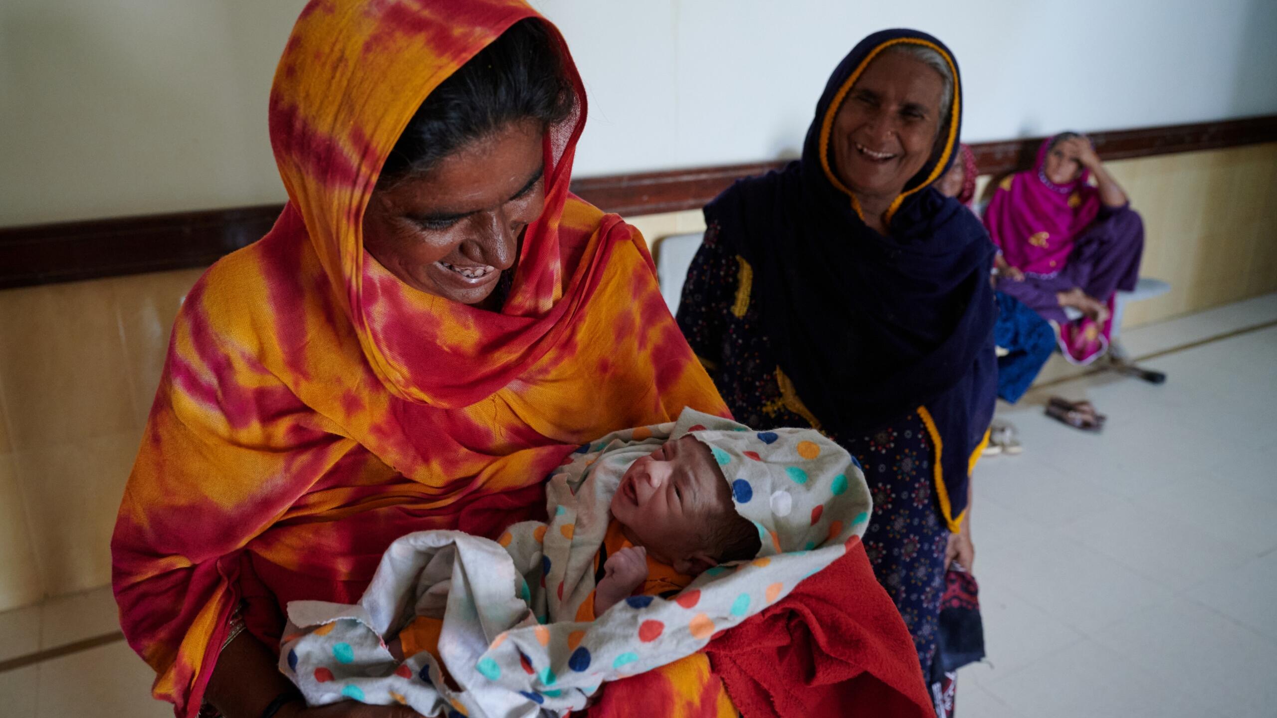A woman smiles at her newborn child.