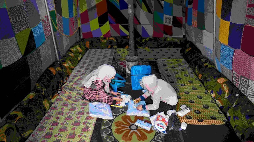 Las adolescentes Salwa (izquierda) y Kholoud revisan el contenido de sus kits de higiene femenina en el campamento de AlSekka, en Idlib, Siria.