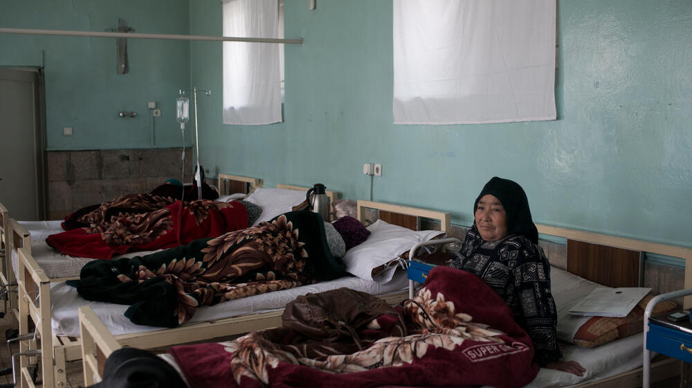 Une femme âgée, survivante de fistule, se repositionne dans son lit dans un centre de santé.