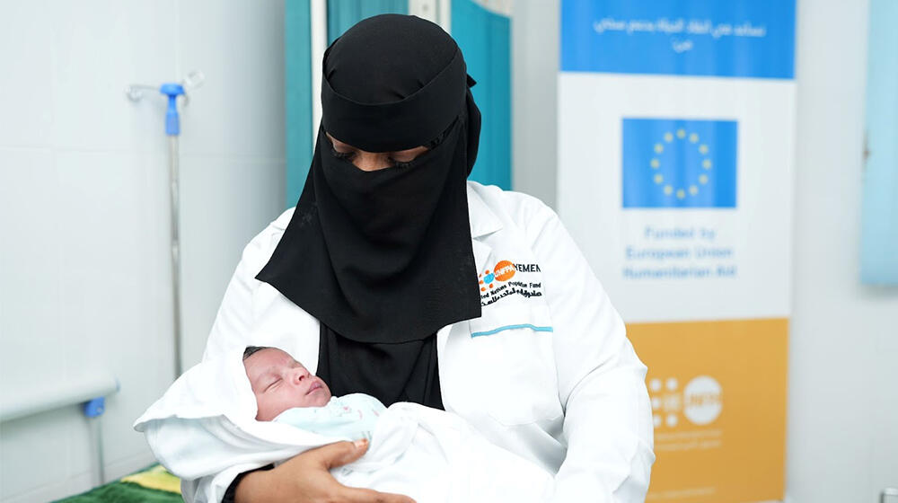  A midwife holds a newborn baby.