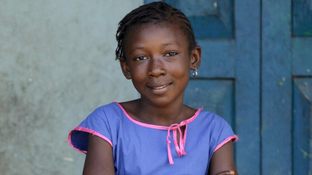 A young girl smiles.