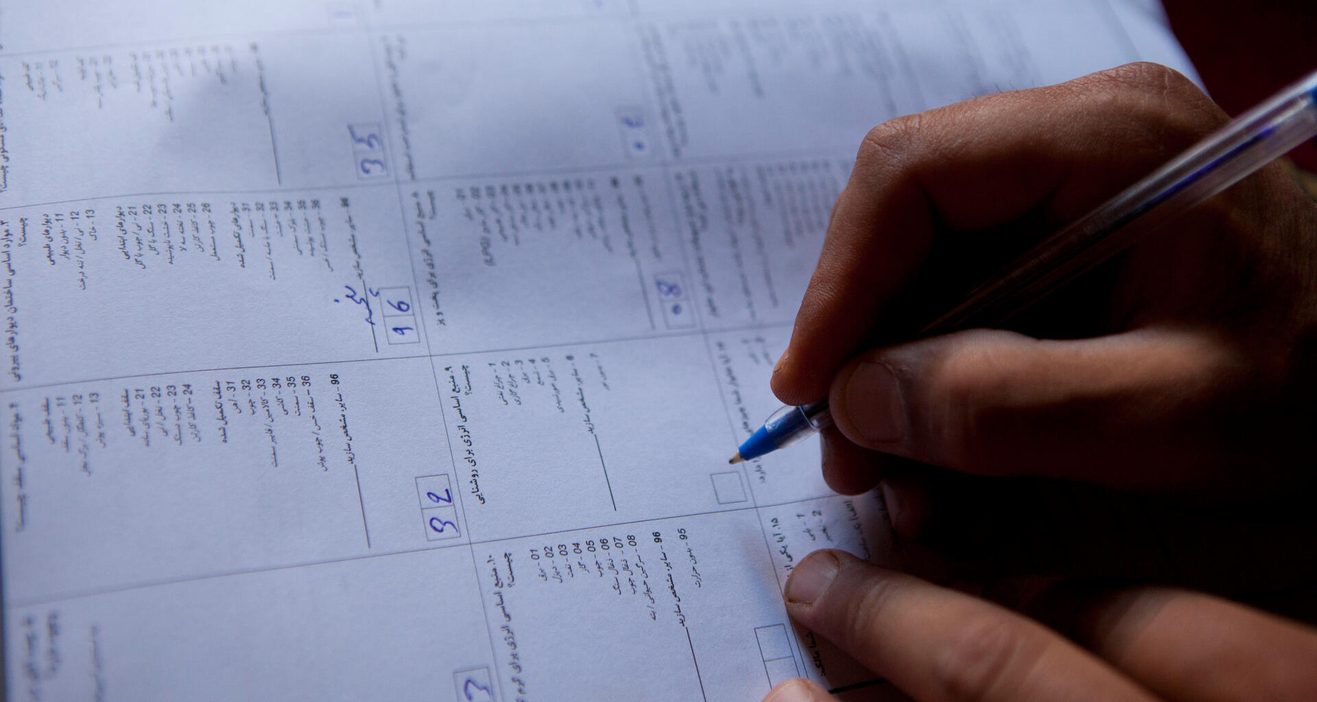 Une main écrit sur un document de recensement.