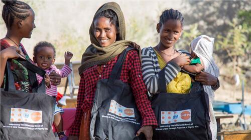 Three displaced women with their babies receive dignity kits with sanitary and hygiene items in Mekele.