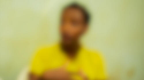 Blurred image of a person wearing a yellow shirt.