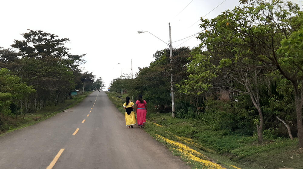 Two women walk along a paved road. For some communities, the nearest health centre is two days away. ©UNFPA Panama/Osman Esquivel López