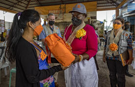 Dr. Kanem hands an orange dignity kit to a young women