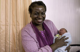 Dr. Natalia Kanem holding a baby at the Zaatari Maternity Clinic Clinic in Jordan. © UNFPA Jordan/Elspeth Dehnert